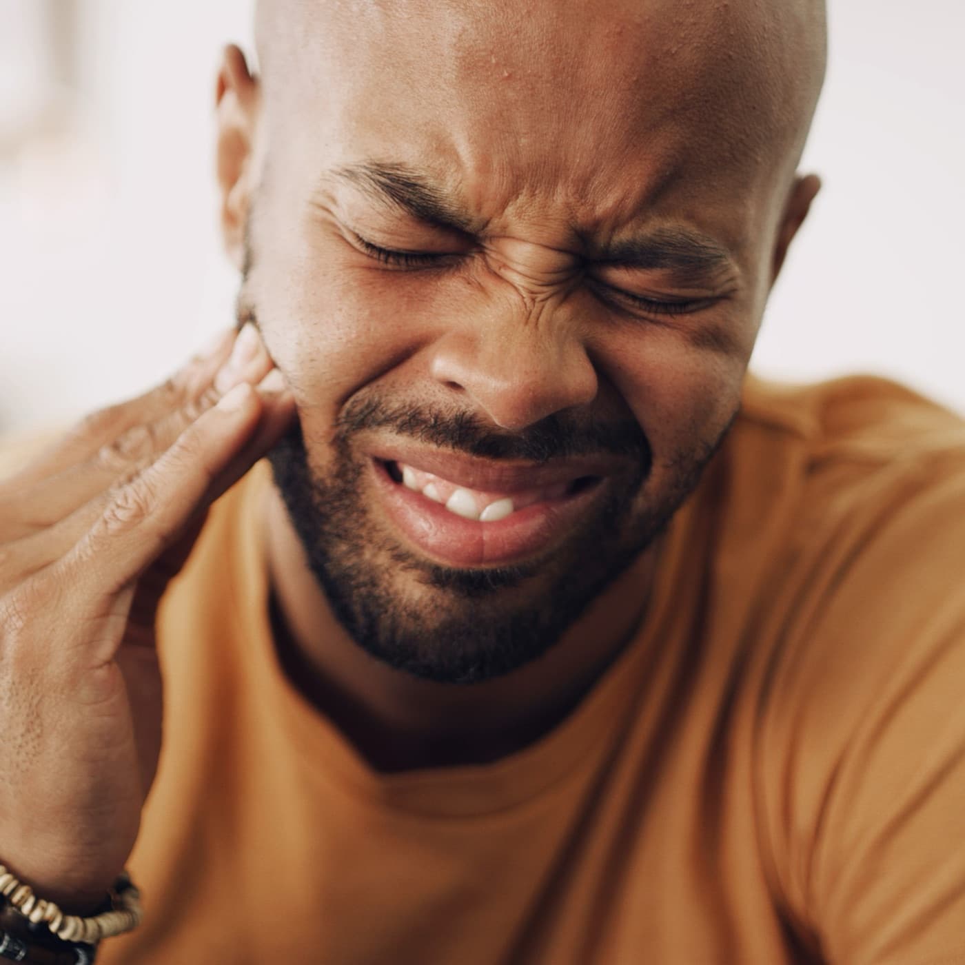 Person holding their jaw in discomfort